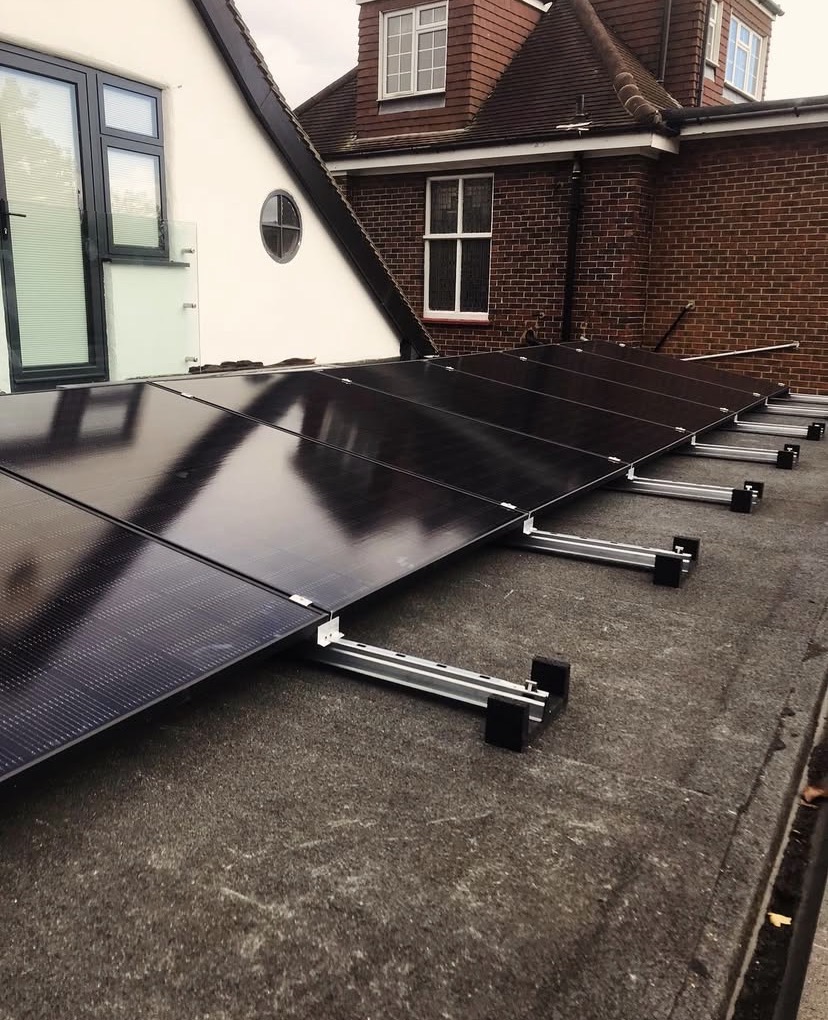 Black solar panels on low mounting rails set back on a flat roof